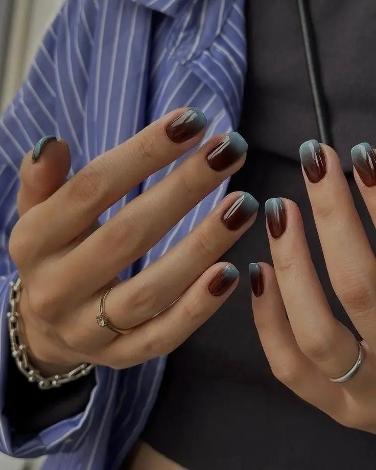 Short glossy nails with a chocolate brown base fading into smoky blue tips